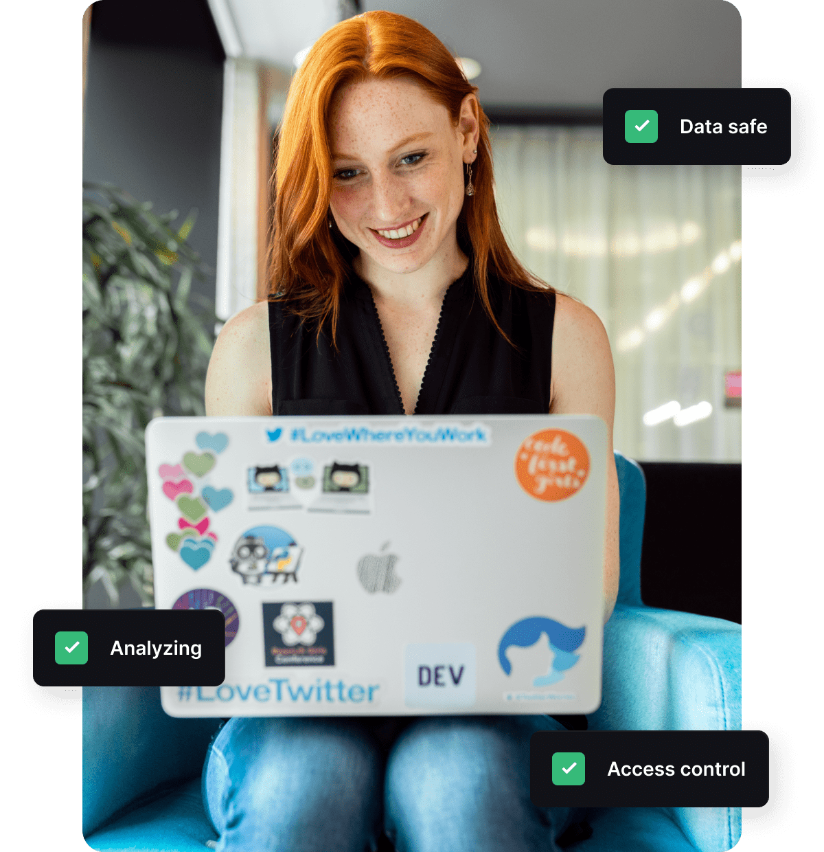 Smiling redhaired woman using laptop adorned with stickers enjoying an online event without worrying about her security and privacy settings